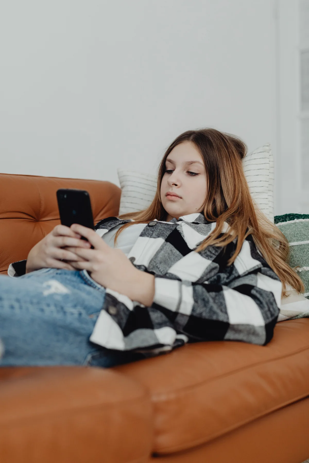 A high school student using a phone during a focused study session